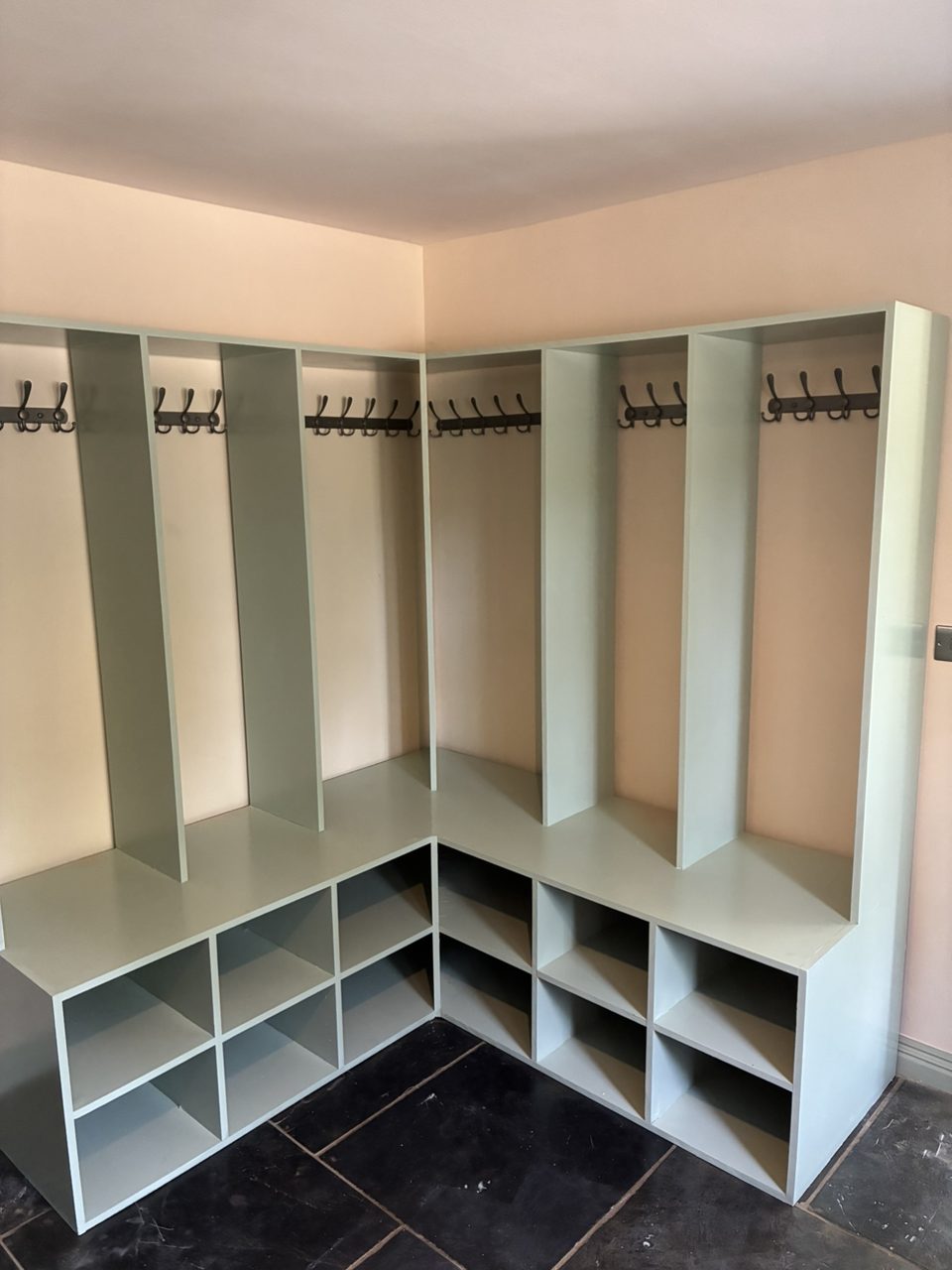 Built-in corner boot room storage with coat hooks and shoe cubbies
