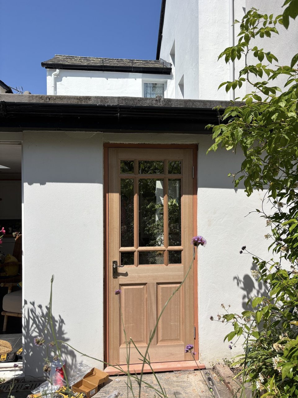 Glazed timber external door fitted into a white rendered wall
